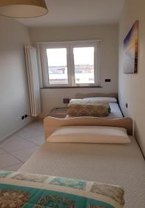 two beds in a room with two windows at Residenza Adriatica 2 in Roseto degli Abruzzi