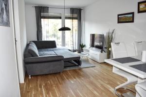 uma sala de estar com um sofá e uma televisão em Cosy new Apartment 3min to VIC/Uno-City and Danube em Viena