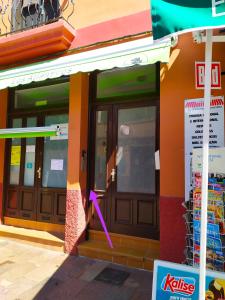 a store front with a pink arrow on the door at Apartamento La Peatonal in San Sebastián de la Gomera