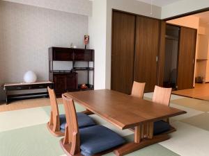 a dining room with a wooden table and chairs at guest house Sakura in Osaka