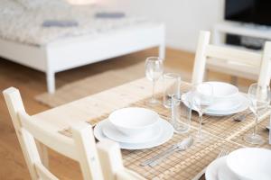 a table with white plates and glasses on it at Vienna City Apartments - Metro 1160 Vienna in Vienna +102 photos
