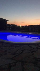 a pool of blue water at night with the sunset at Chalés Alternativa in Conceição da Ibitipoca