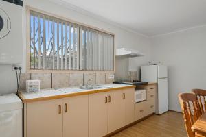 a kitchen with a sink and a large window at SWANSEA VILLAS in Swansea