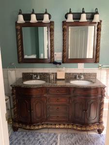 a bathroom with two sinks and two mirrors at The Inn at Benicia Bay in Benicia