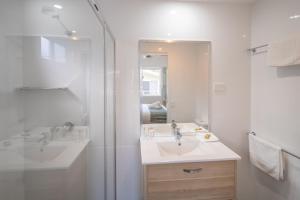 a bathroom with a sink, mirror, and bathtub at Ingenia Holidays Lake Conjola in Conjola