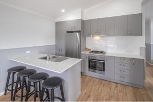 a kitchen with a stove top oven and a sink at Ingenia Holidays Lake Conjola in Conjola