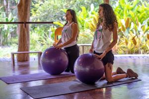 two women standing next to two large exercise balls at Tree House Beachfront Lodge in Puerto Viejo