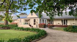 Glen Isla House Bed & Breakfast Phillip Island في كاوز: منزل أبيض مع شرفة وساحة