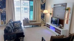 un soggiorno con divano e TV di Tropicana Home Concept@Saujana KLIA, Sepang a Sepang