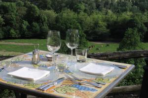 una mesa con copas de vino y servilletas. en Fattoria l'Amorosa, en Sementina