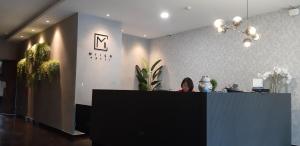 a woman sitting at a counter in a lobby at MIICO Hotel @ Mount Austin in Johor Bahru