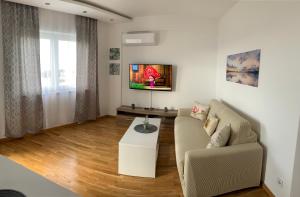 a living room with a couch and a tv at Ive Lole Ribara 38 in Becici