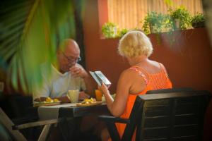 Un uomo e una donna seduti a tavola mangiando cibo di Oasis Yoga Bungalows a Ko Lanta