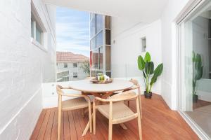 a dining room with a table and chairs on a balcony at ULTIMATE BONDI LIVING in Sydney