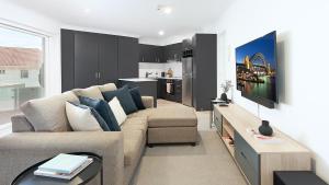a living room with a couch and a kitchen at ULTIMATE BONDI LIVING in Sydney