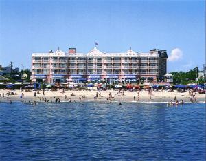 a group of people on the beach in front of a hotel at Boardwalk Plaza Hotel in Rehoboth Beach