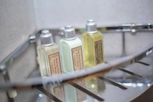 a shelf with four bottles of soap on it at Floral Hotel ·Hefu Hotel (Hangzhou West Lake) in Hangzhou