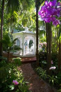 a white gazebo in a garden with purple flowers at The Gardens Hotel in Key West