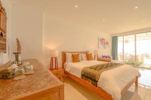 - une chambre avec un grand lit et une table dans l'établissement Gili Meno Mojo Beach Resort, à Gili Meno