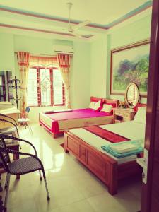 a bedroom with two beds and a chair at Yen Minh Hotel Thien An in Na Thôn