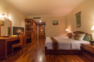 1 dormitorio con cama, escritorio y ordenador en Khemara Angkor Hotel & Spa, en Siem Reap
