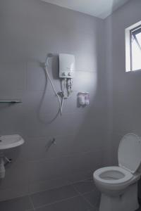 a white bathroom with a toilet and a sink at Hotel ali Imran in Putrajaya