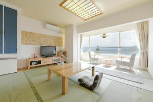 a living room with a table and a television at Hotel Ra Kuun in Hakone