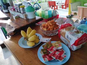 two plates of food on a table with bananas and other food at บ้านฟ้ารักตะวัน in Cha Am