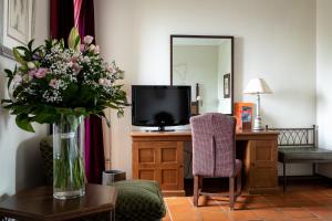 ein Wohnzimmer mit einer Blumenvase auf dem Tisch in der Unterkunft Parador de Monforte de Lemos in Monforte de Lemos