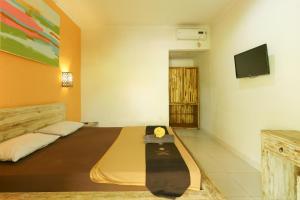 a bedroom with a bed with a skateboard on it at The Legian Mas Beach Inn in Kuta