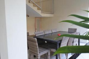 une salle à manger avec une table et des chaises noires dans l'établissement Morse Guest house, à Malang