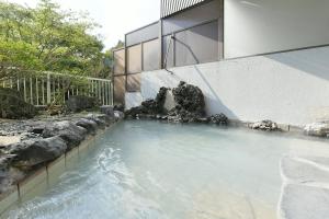 une piscine d'eau en face d'un bâtiment dans l'établissement Hotel Ra Kuun, à Hakone