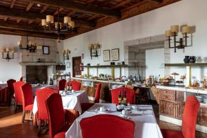 restauracja ze stołami i czerwonymi krzesłami oraz bar w obiekcie Parador de Monforte de Lemos w mieście Monforte de Lemos