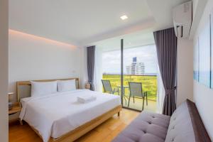 a hotel room with a bed and a balcony at Rocco Hua Hin Beach Seaview in Hua Hin