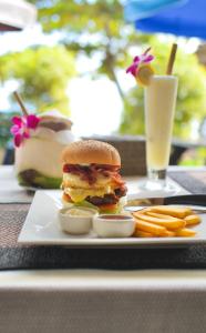 un sándwich en un plato con papas fritas y una bebida en Coco Garden Resort, en Thong Sala