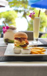a sandwich on a plate with fries and a drink at Coco Garden Resort in Thong Sala