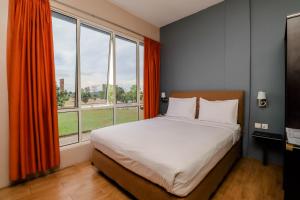 瑟古邦Blitz Hotel Batam Near Sultan Mahmud Ri'ayat Shah的一间带床和大窗户的卧室