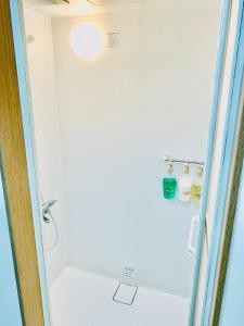 a bathroom with a shower with a glass door at Hostel Jumpu Manpan in Otaru