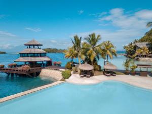 a resort swimming pool with a view of the ocean at Pearl Farm Beach Resort in Samal