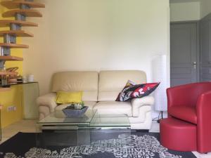 a living room with a white couch and a red chair at Maison à la Campagne à 2km du Circuit de Bresse in Sagy