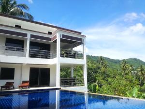 een villa met een zwembad en bergen op de achtergrond bij Koh Samui Palm View Villa in Chaweng Beach