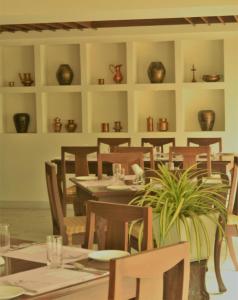 a dining room with a table and chairs and vases at Hotel Ranjith in Chennai