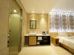 Almond Hotel Busan Station في بوسان: حمام مع حوض وسرير ومغسلة