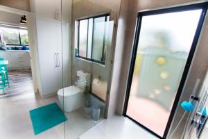 a bathroom with a toilet and a glass door at Coorong Cabins in Meningie