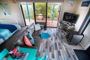 a living room with a couch and a tv at Coorong Cabins in Meningie