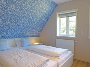 una camera da letto con un letto e una parete a motivi blu di Friesenhaushälfte Backbord a Nebel