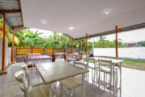 a dining area with tables and chairs on a patio at Jeri Home Stay in Kuta Lombok