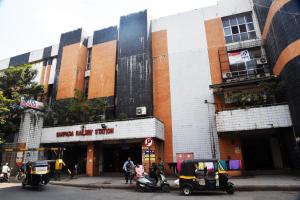 een gebouw met twee golfkarretjes die er voor geparkeerd staan bij Hotel Indiana Inn in Navi Mumbai