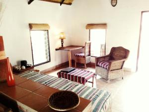 sala de estar con sofá, sillas y mesa en Barefoot Lodge and Safaris - Malawi en Lilongüe