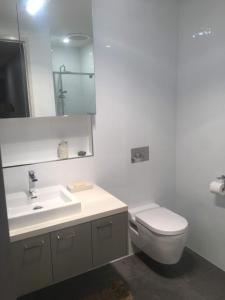 a white bathroom with a toilet and a sink at Central apartment with stairs in Ballarat